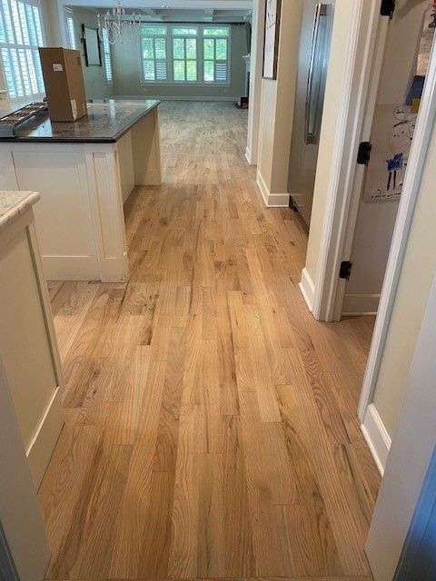 a kitchen with hardwood floors and white cabinets.