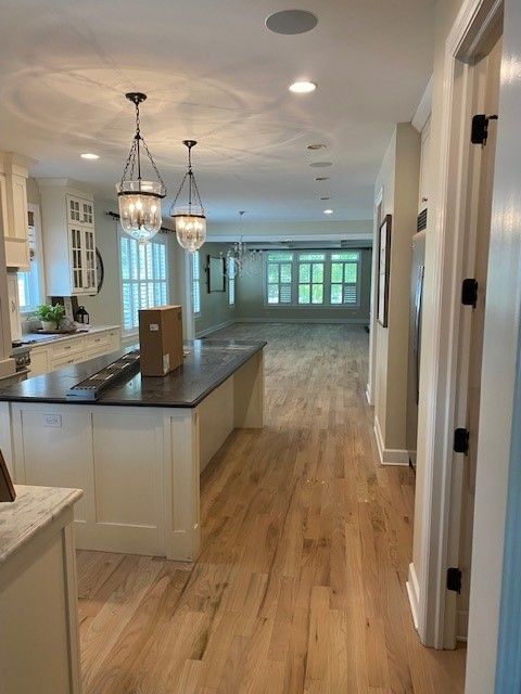 a kitchen with hardwood floors and white cabinets