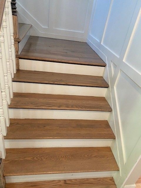 a staircase with wooden steps and white railing in a house.