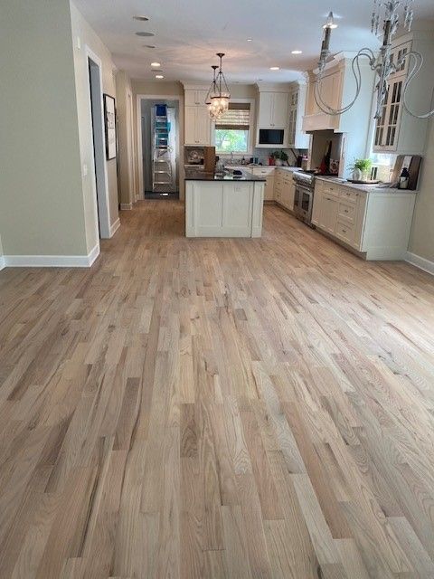 a kitchen with a wooden floor and white cabinets.