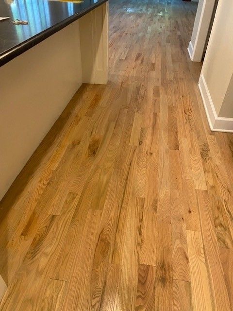 a kitchen with hardwood floors and a black countertop.