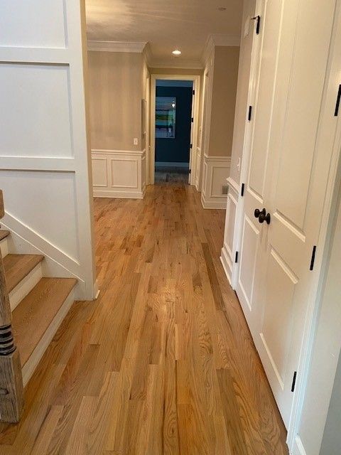 a hallway with hardwood floors and stairs in a house 