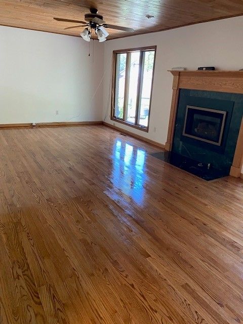 an empty living room with hardwood floors and a fireplace