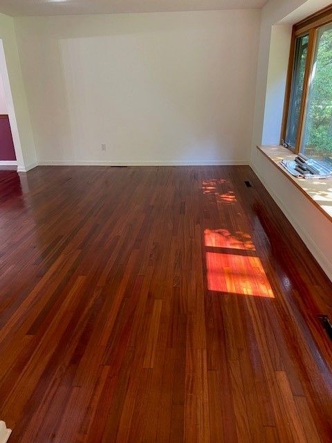a living room with hardwood floors and a window