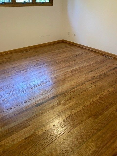an empty room with hardwood floors and a window