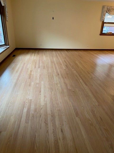 a living room with a wooden floor and a window