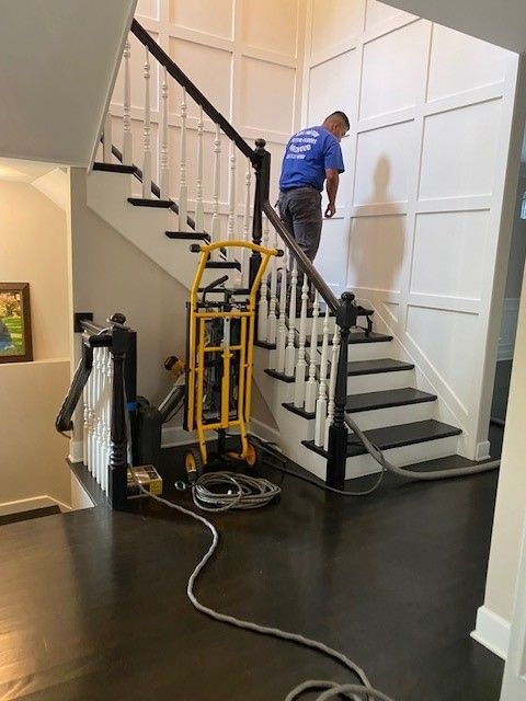 a man in a blue shirt is standing on a set of stairs.