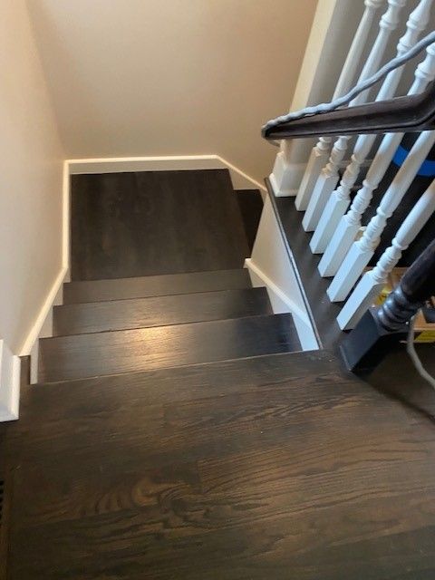 a wooden staircase with a white railing in a house.