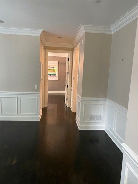 a hallway in a house with hardwood floors and white trim.