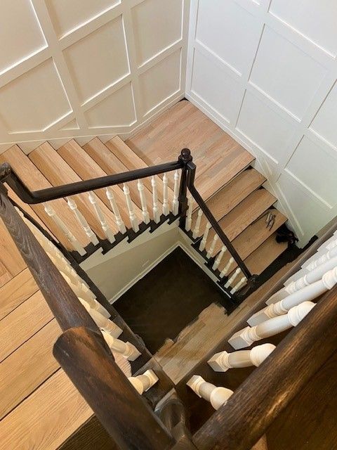 a staircase with wooden steps and a black railing
