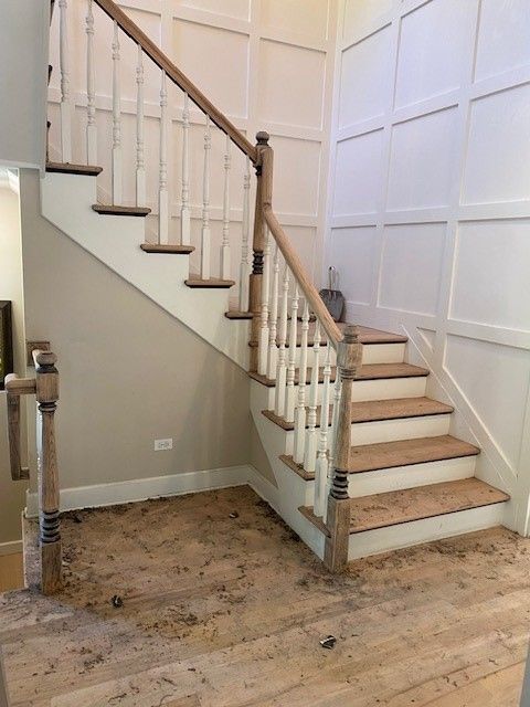 a staircase with wooden steps and white railings in a hallway.