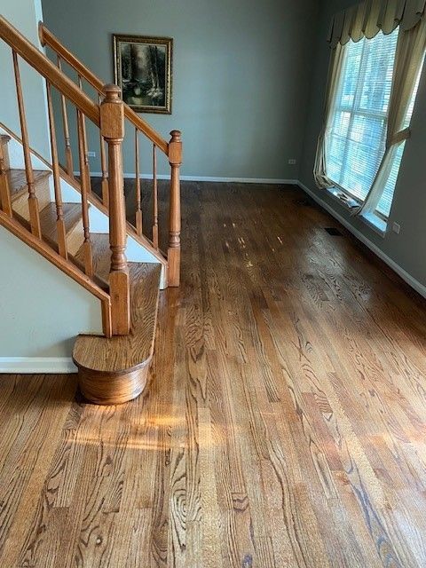 an empty living room with hardwood floors and stairs.