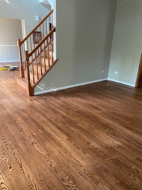 a living room with hardwood floors and stairs in a house.