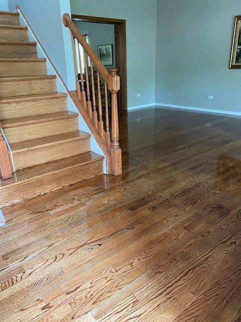 a wooden staircase in a living room with hardwood floors.