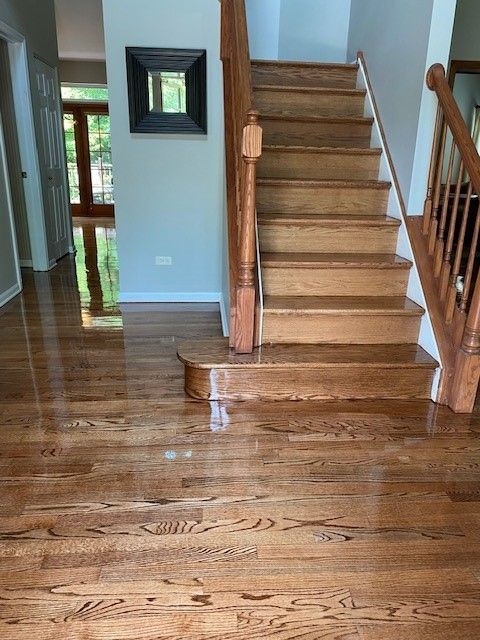 a wooden staircase in a house with a mirror on the wall.