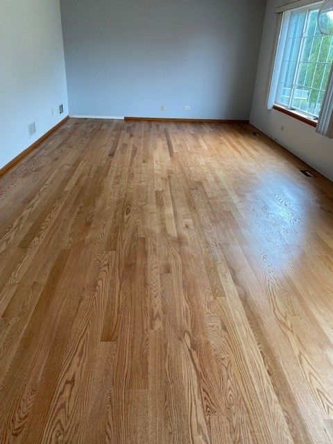 a living room with hardwood floors and a window.