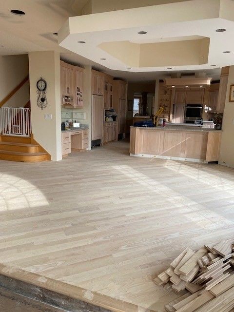 an empty kitchen with a wooden floor and stairs