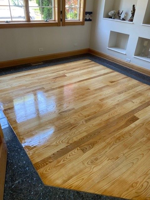 a living room with a wooden floor and a window.