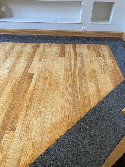 a wooden floor with a black border in a living room.