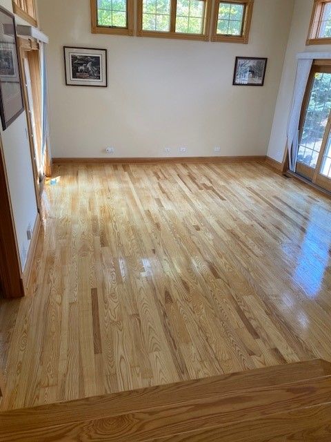 a living room with hardwood floors and a lot of windows.