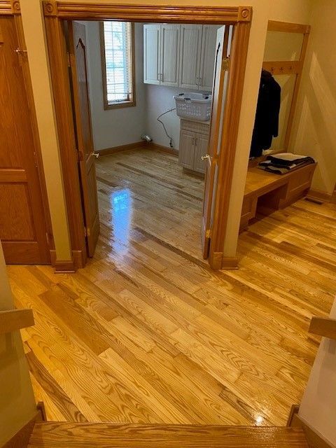 a hallway with hardwood floors leading to a laundry room .