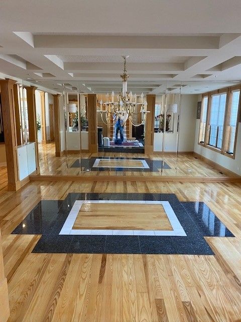a large room with a wooden floor and a black and white tile floor