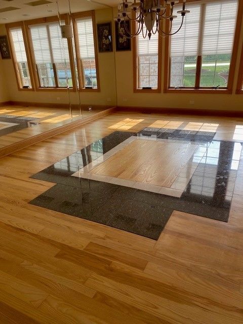 a large room with a wooden floor and lots of windows.