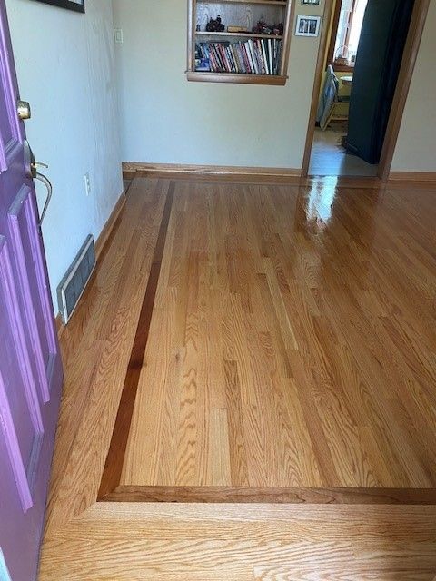 a wooden floor in a room with a purple door .