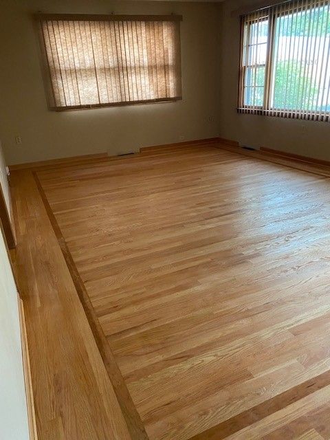 a living room with hardwood floors and a window.