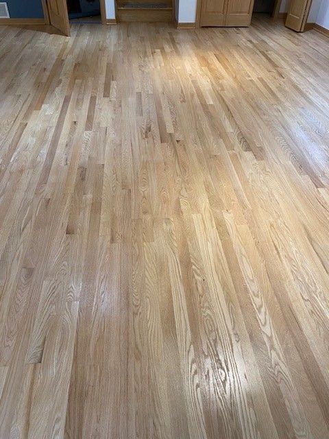 a living room with a wooden floor and a door.