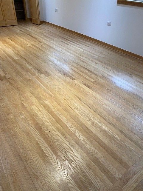 a bedroom with a wooden floor and white walls.