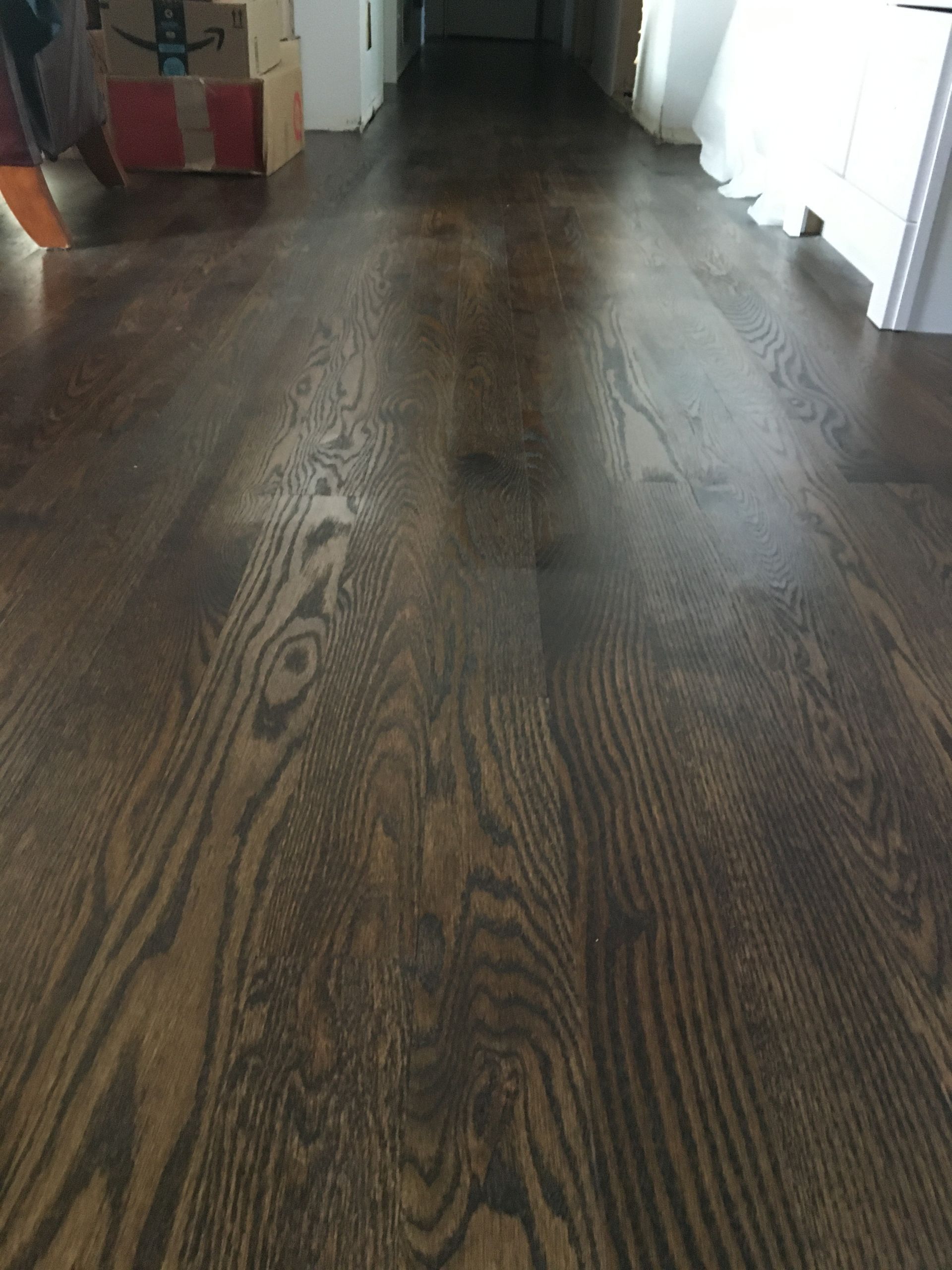 a wooden floor in a living room with boxes on it.