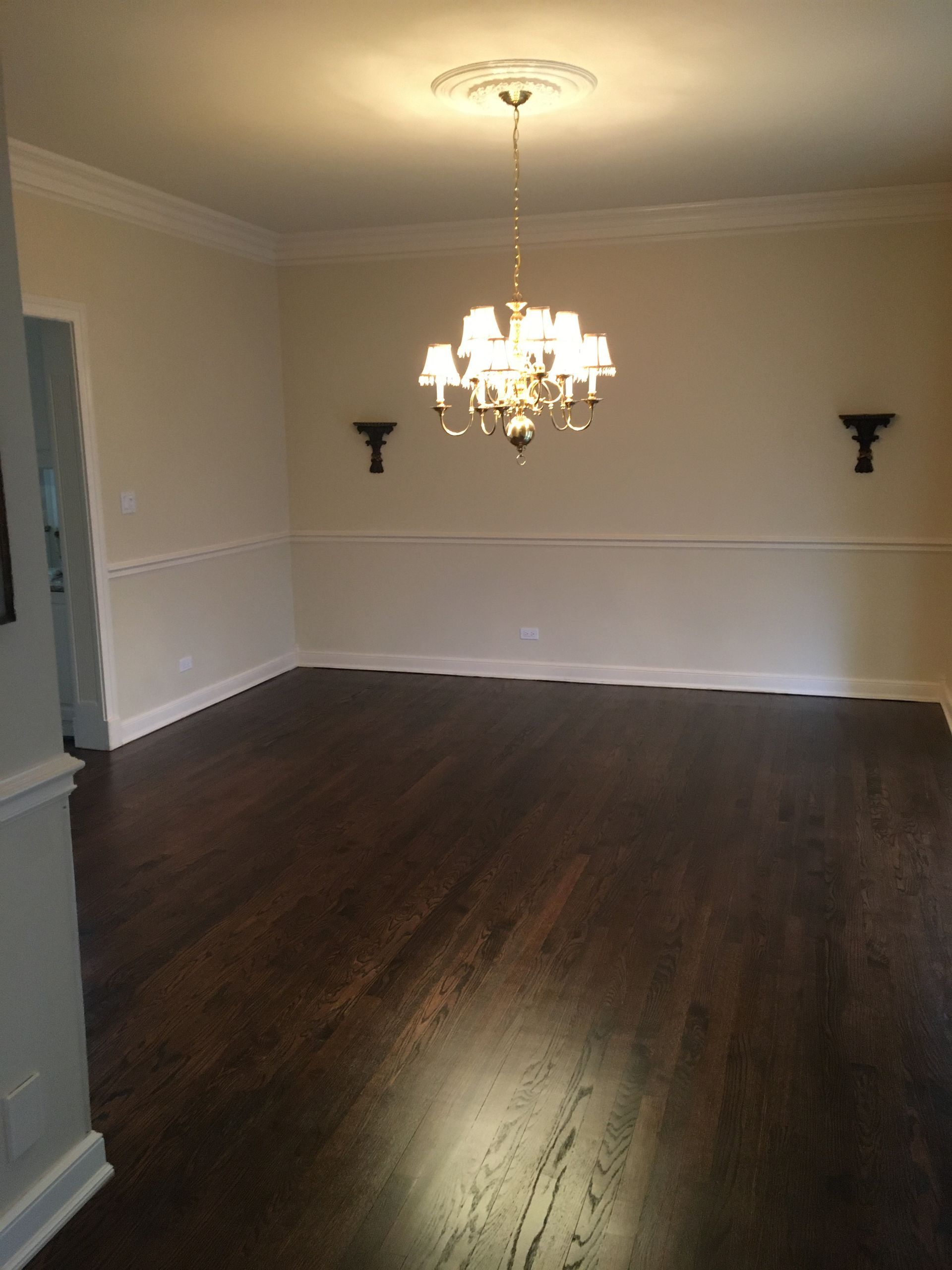an empty dining room with a chandelier hanging from the ceiling