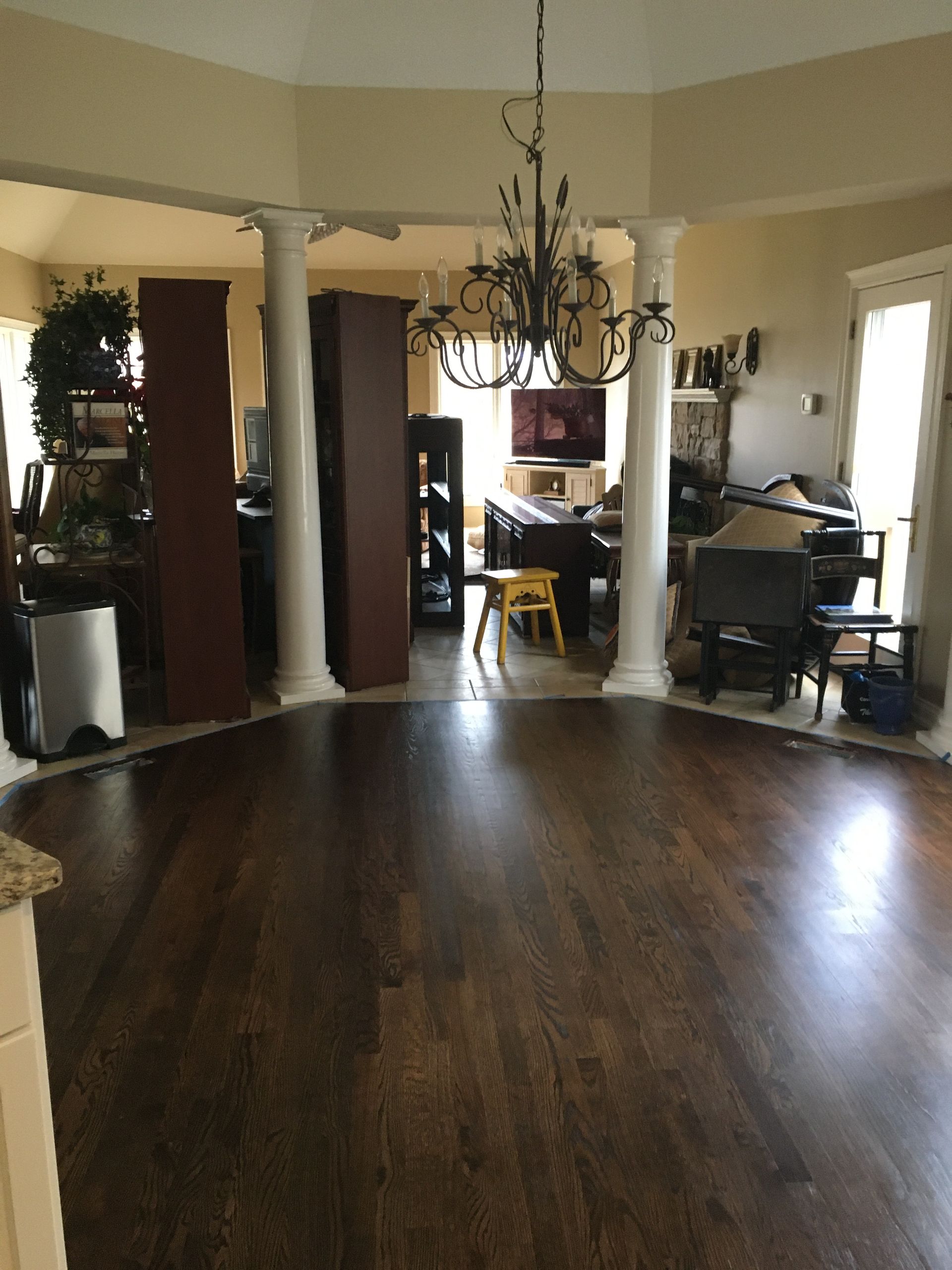 a living room with hardwood floors and a chandelier hanging from the ceiling.