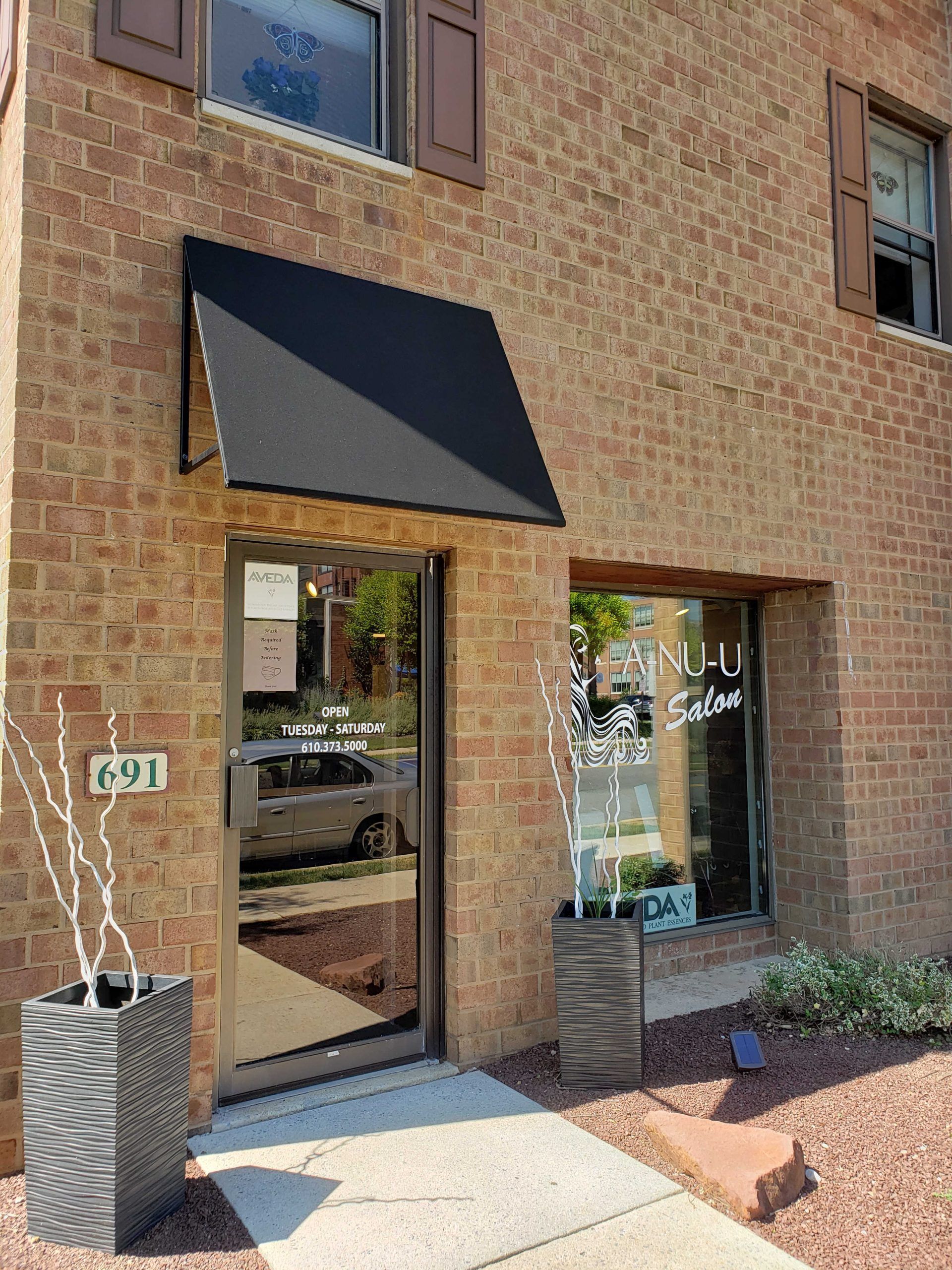 A brick building with a black awning over the door