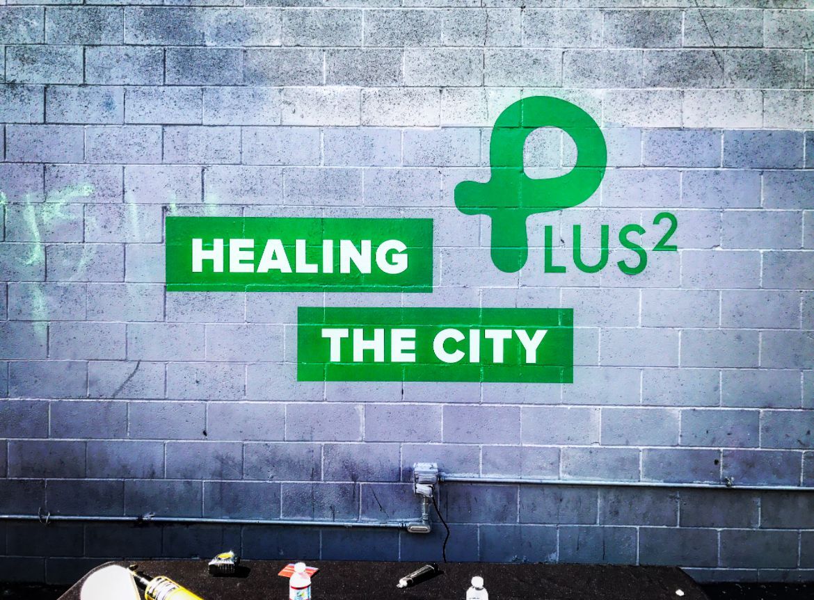 A brick wall with the words healing the city painted on it