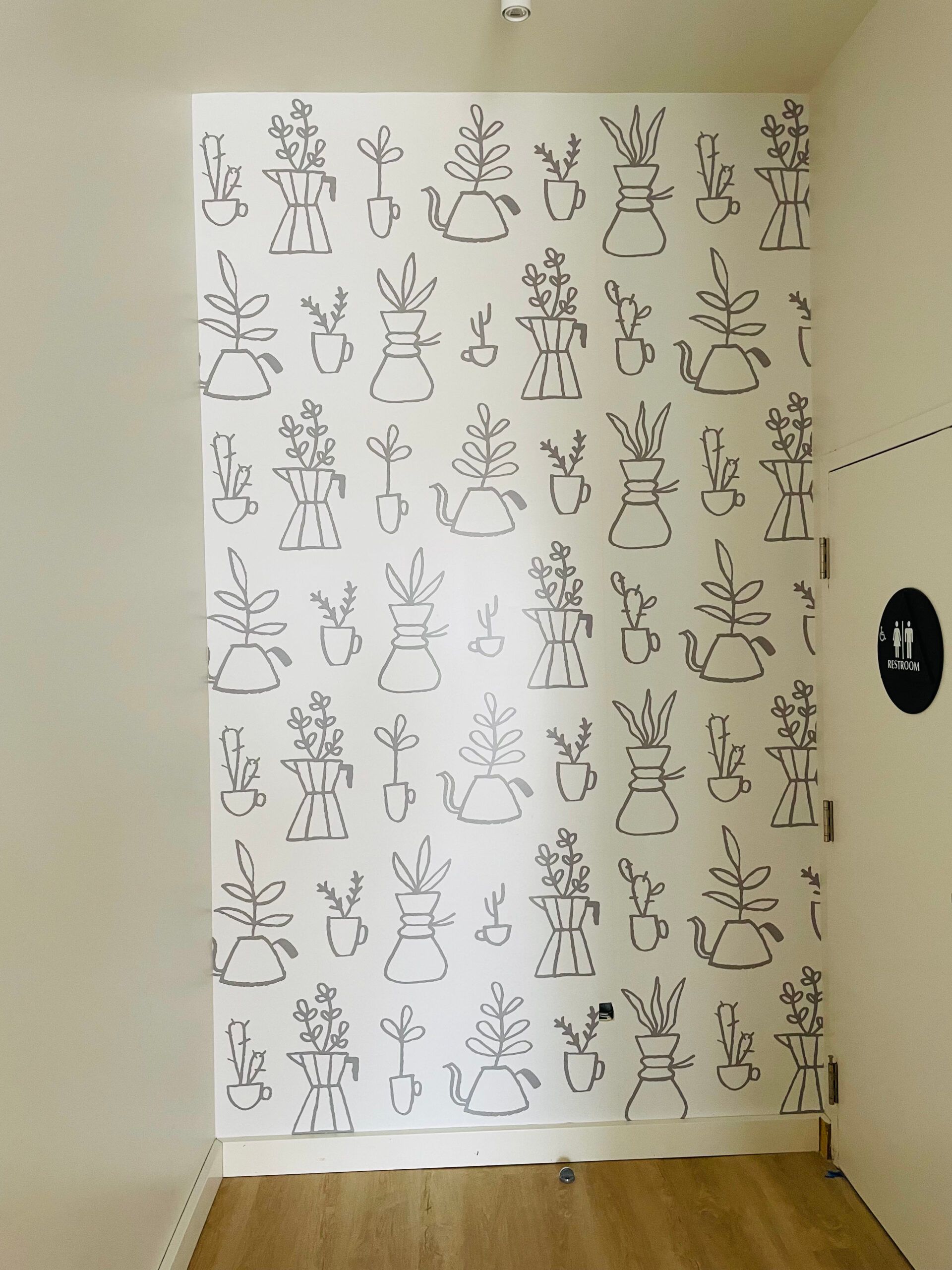 A white wall with a pattern of drawings on it