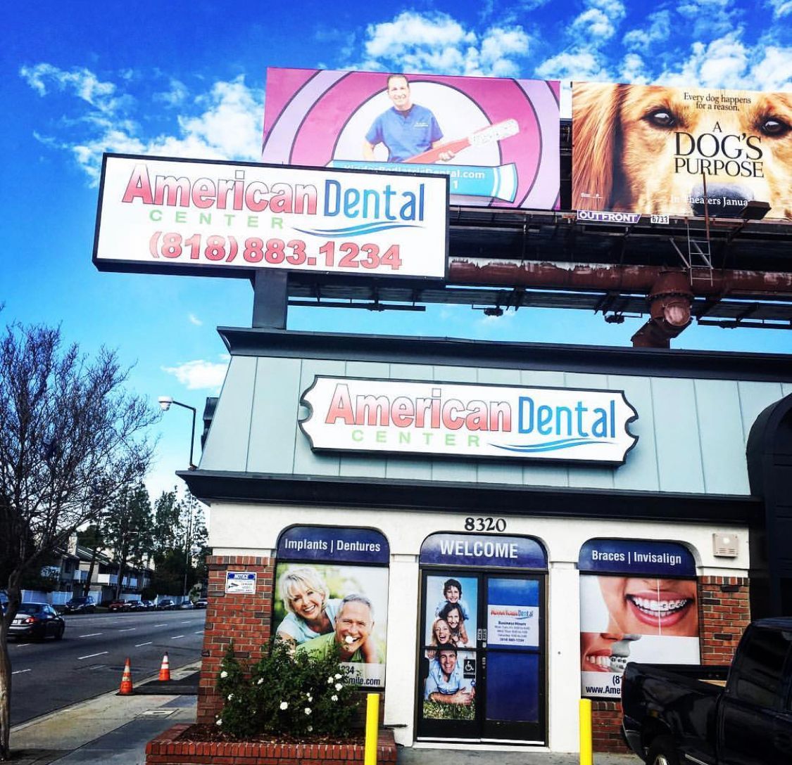 A billboard for american dental center is above a building