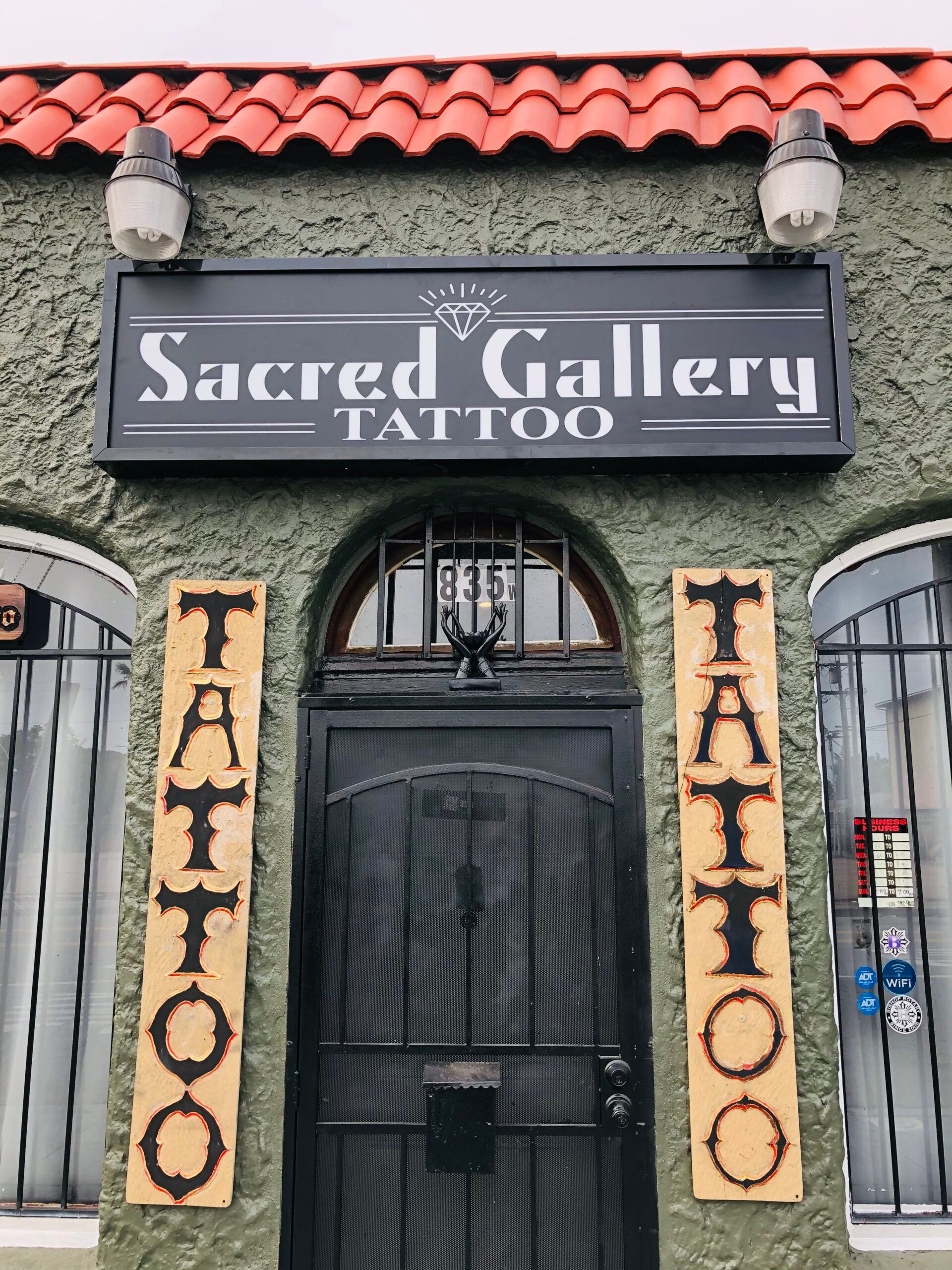 A building with a sign that says sacred gallery tattoo