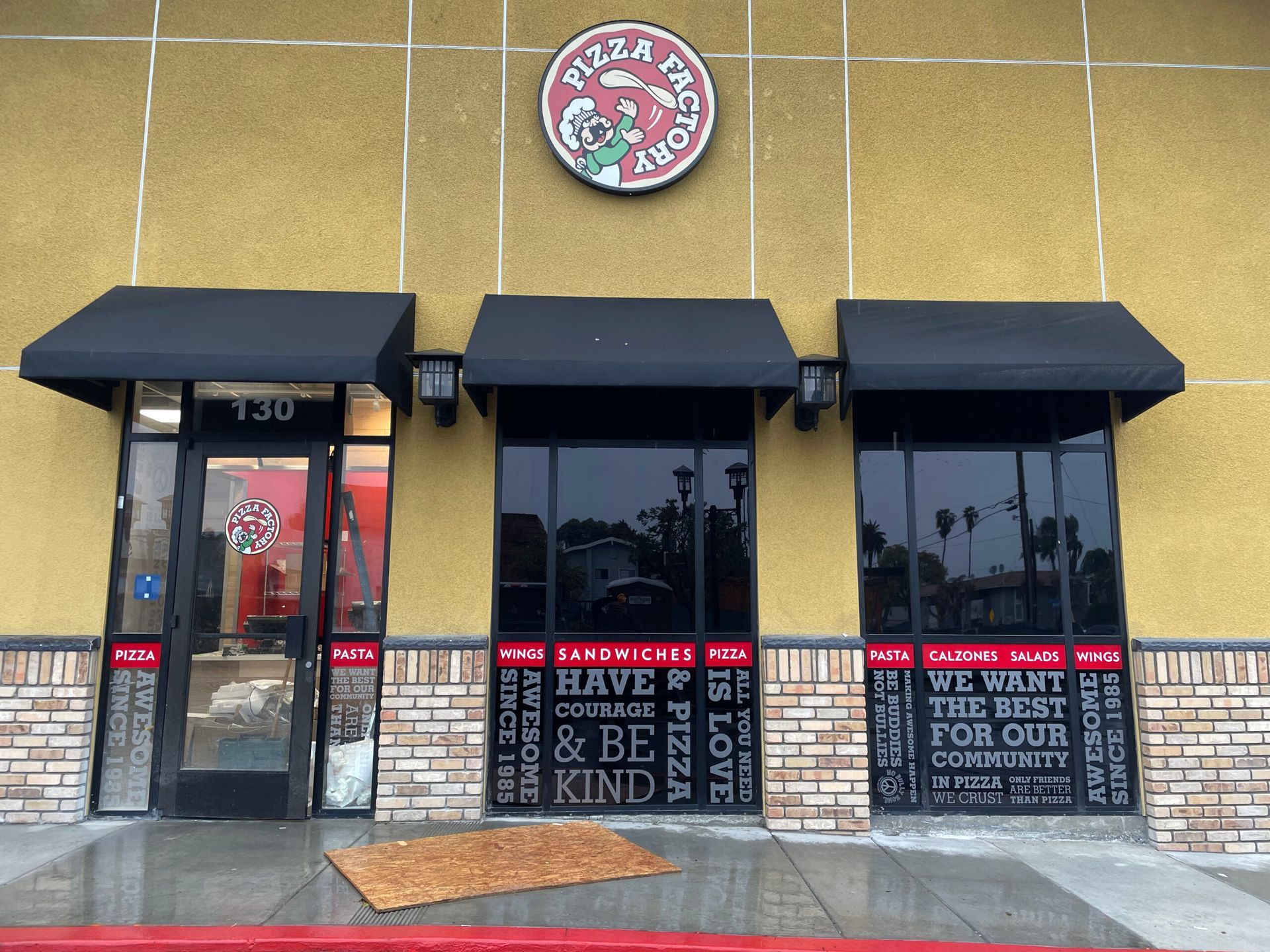 The front of a pizza hut restaurant with black awnings