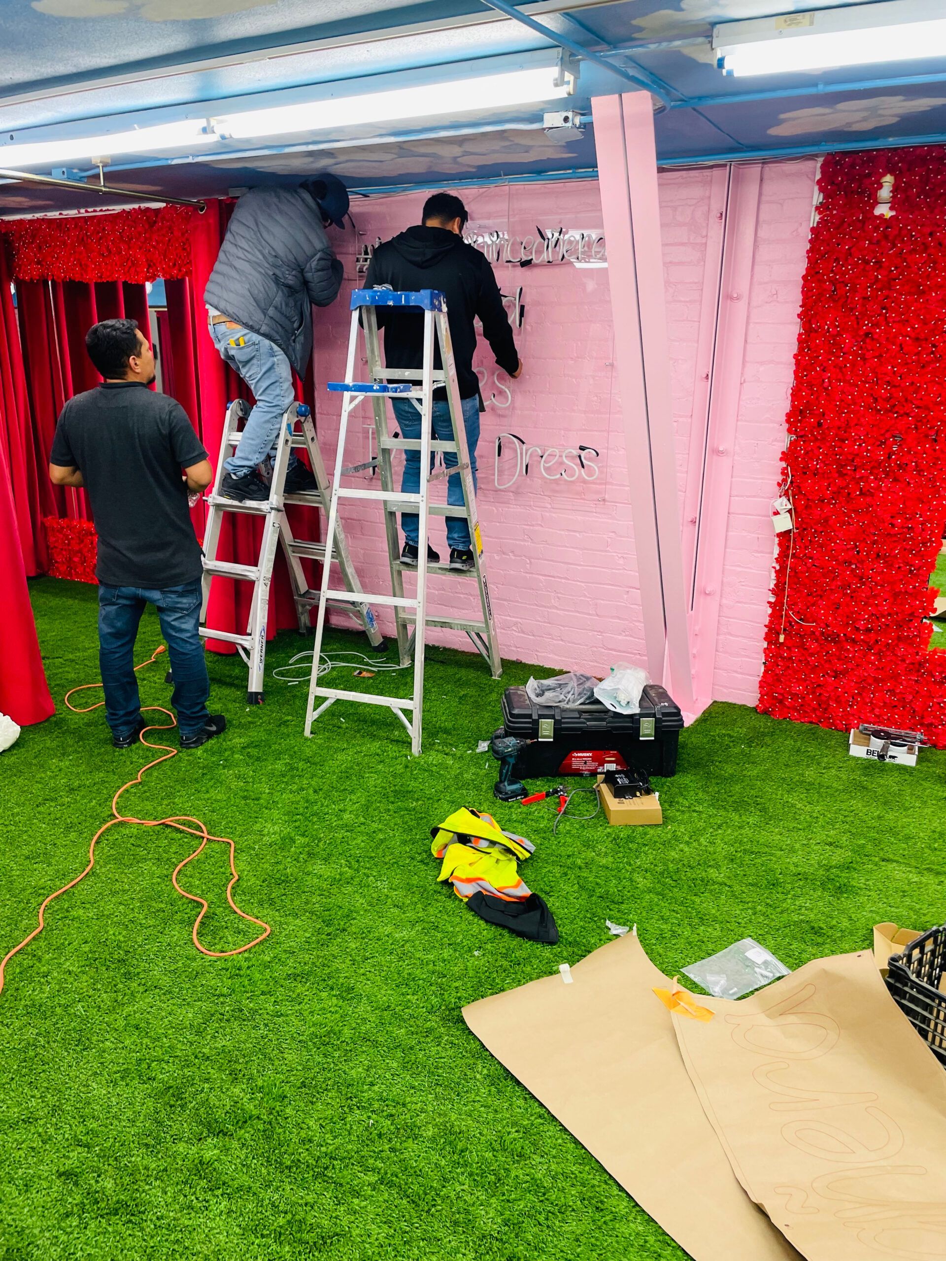 A group of men are working on a wall in a room.