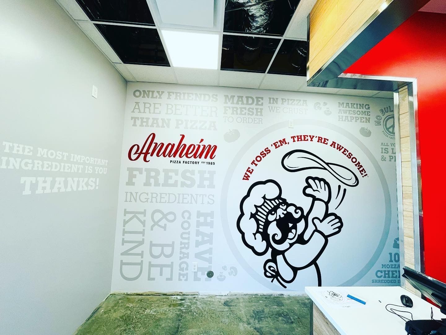 A wall with a picture of a man holding a pizza paddle