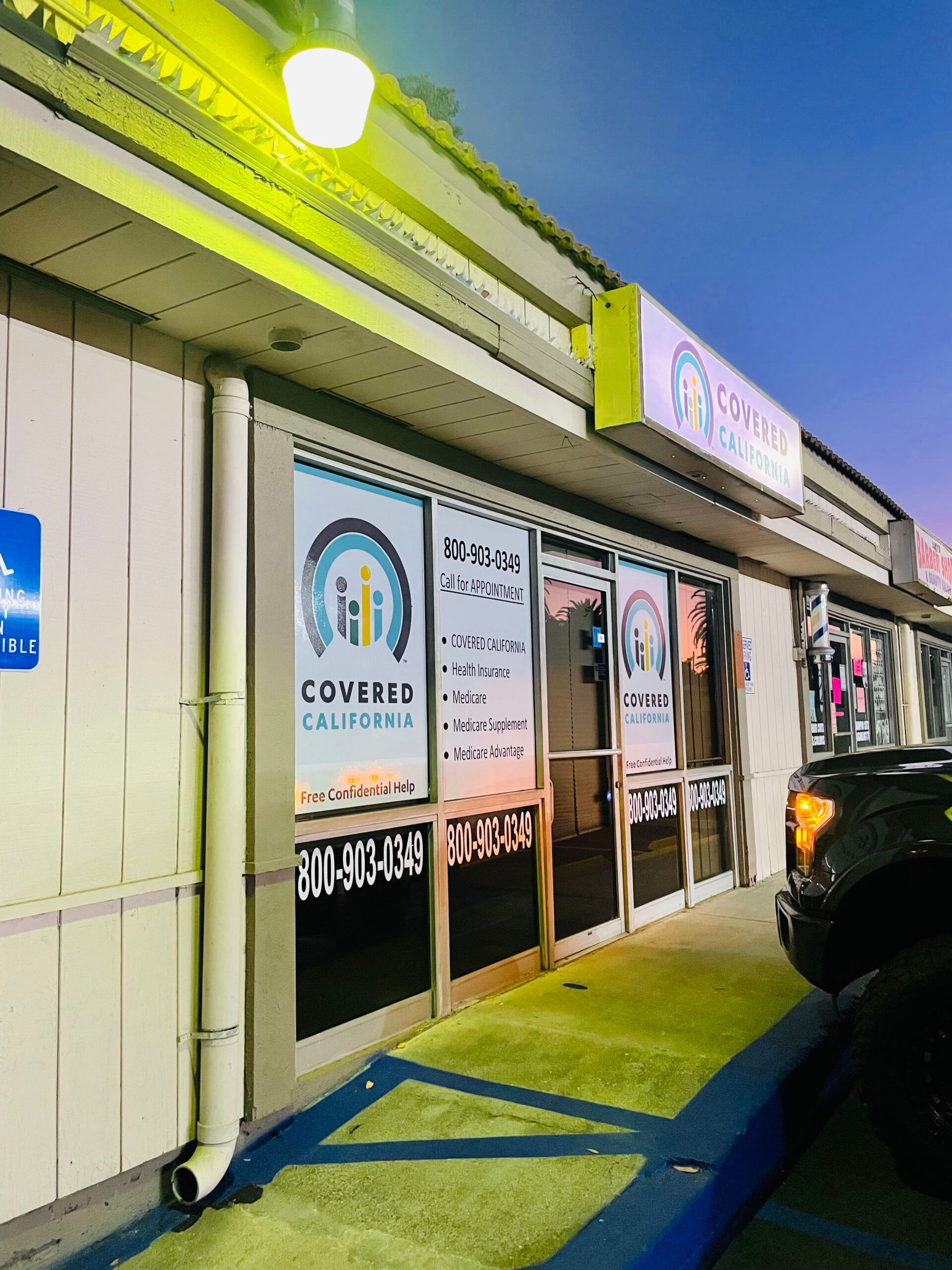 A truck is parked in front of a building that says covers california