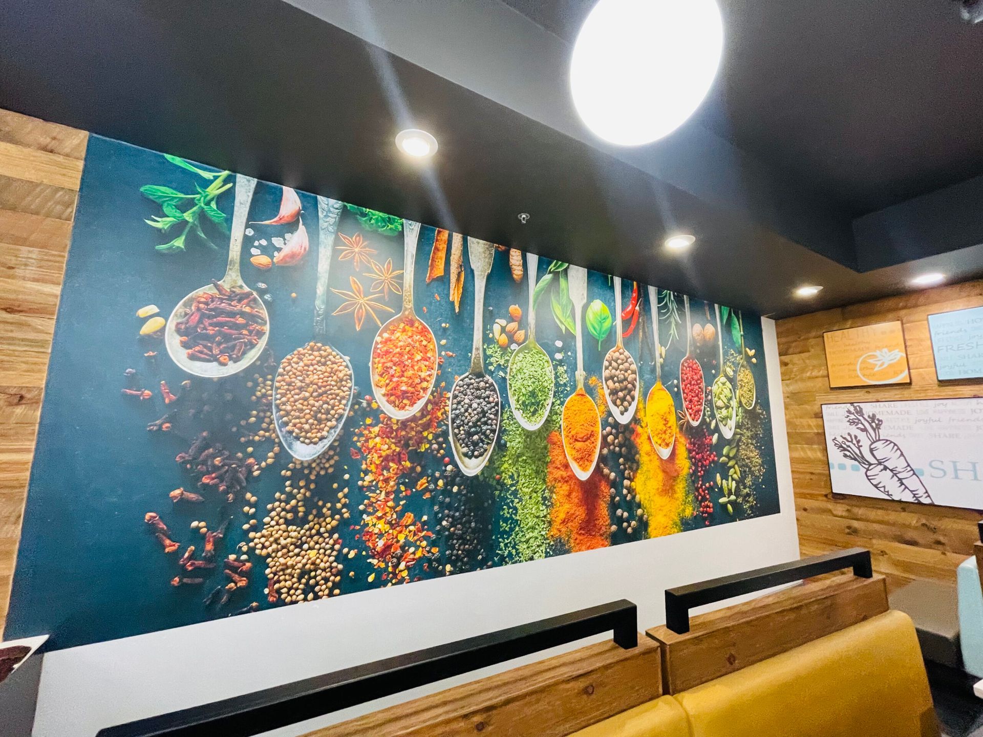 A wall with a picture of spices and spoons on it.