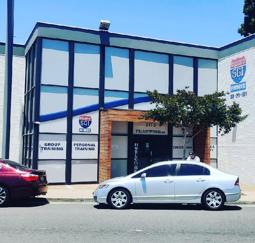 A white car is parked in front of a building that says highway 96
