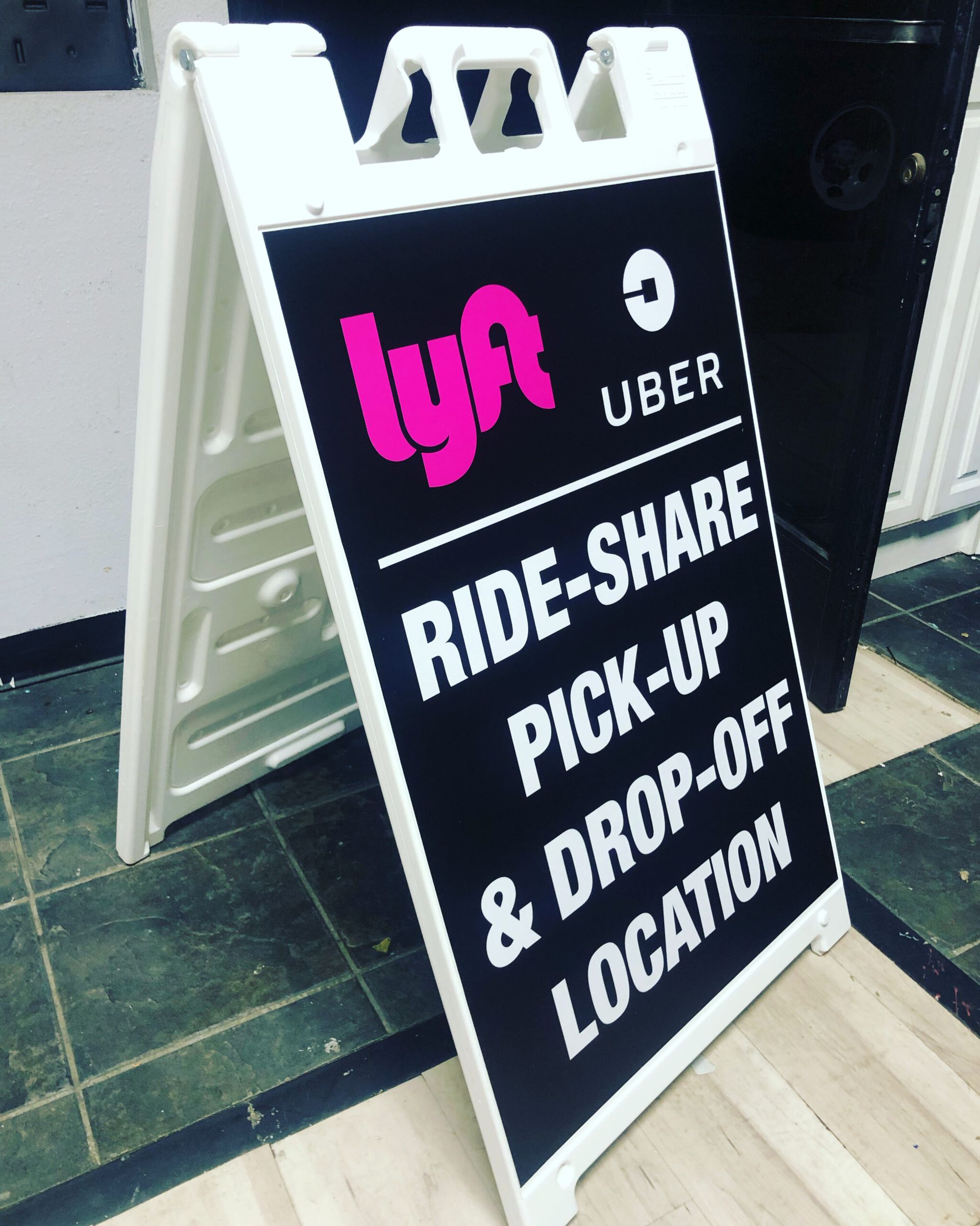 A sign that says ride share pick up and drop off location