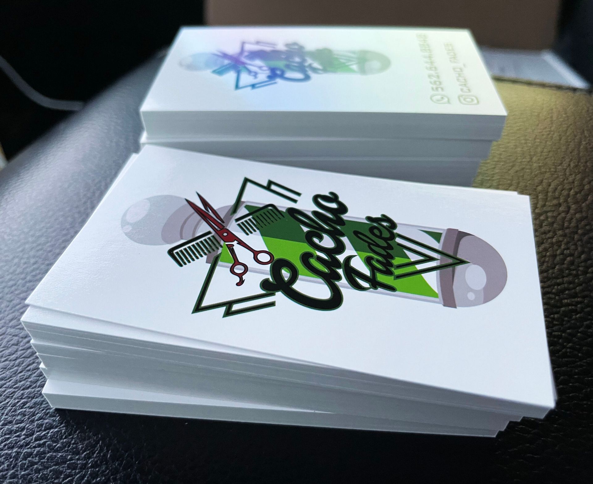 A stack of business cards for cacha barbers