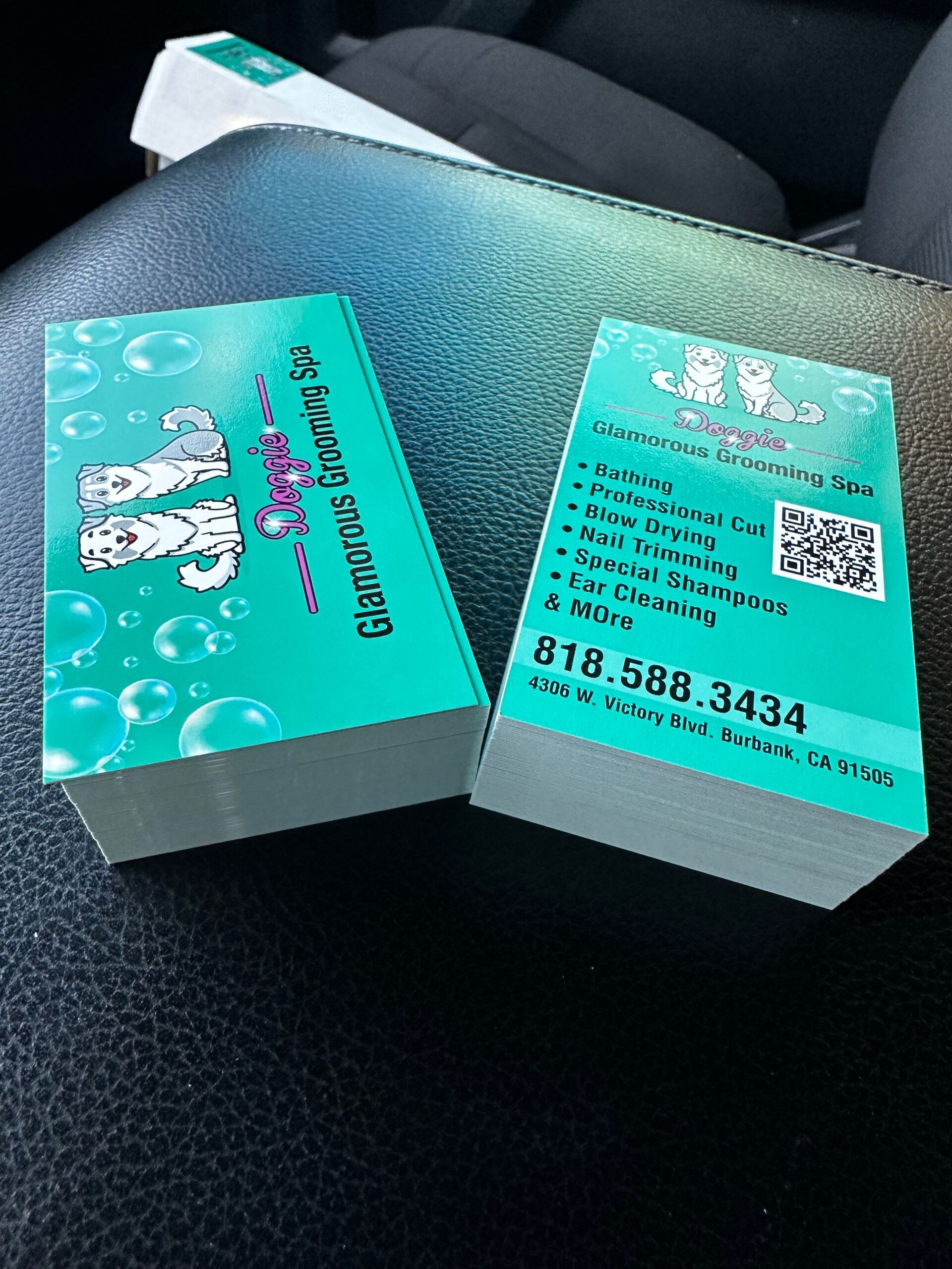 Two business cards are stacked on top of each other