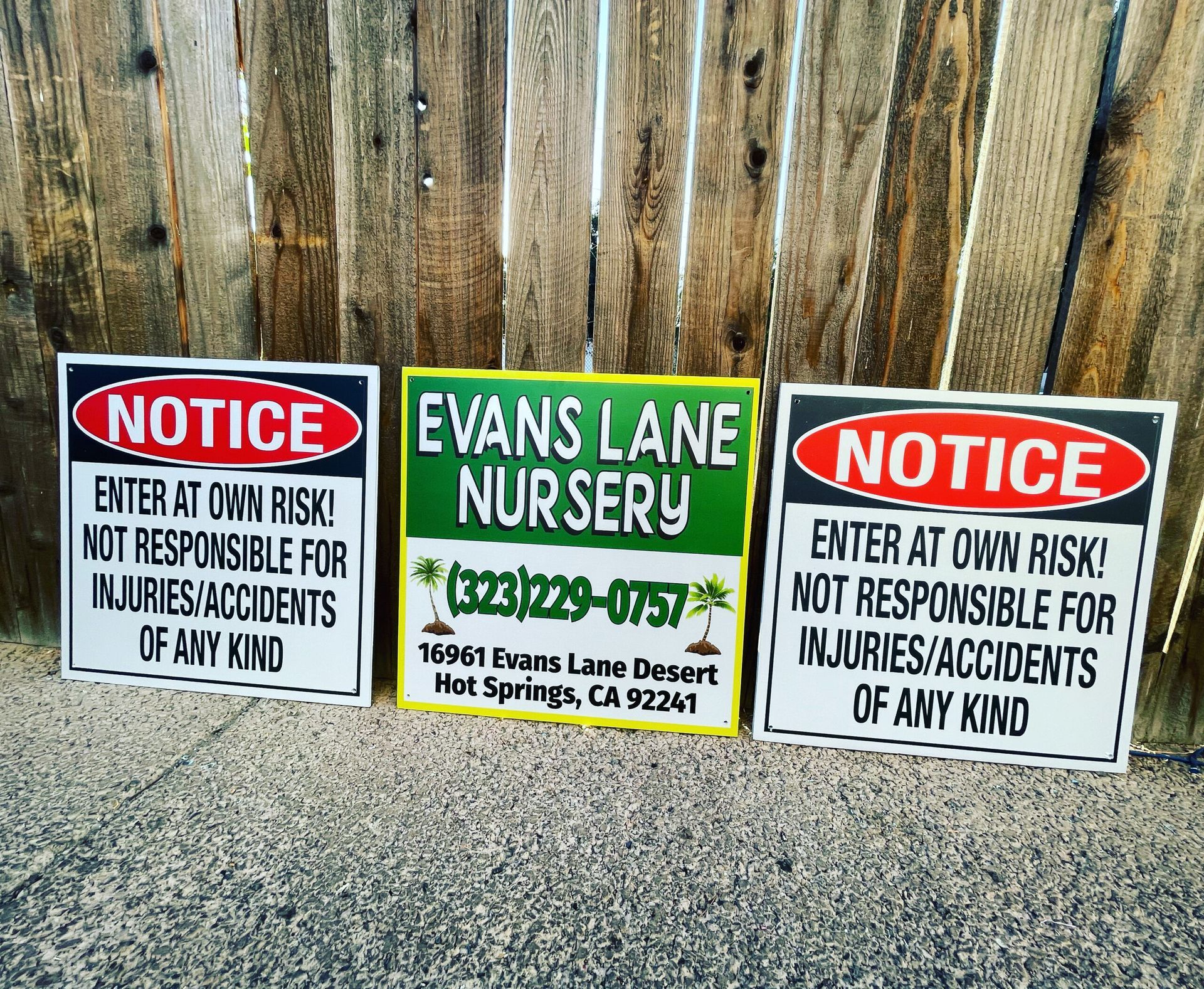 Three notice signs for evans lane nursery on a wooden fence
