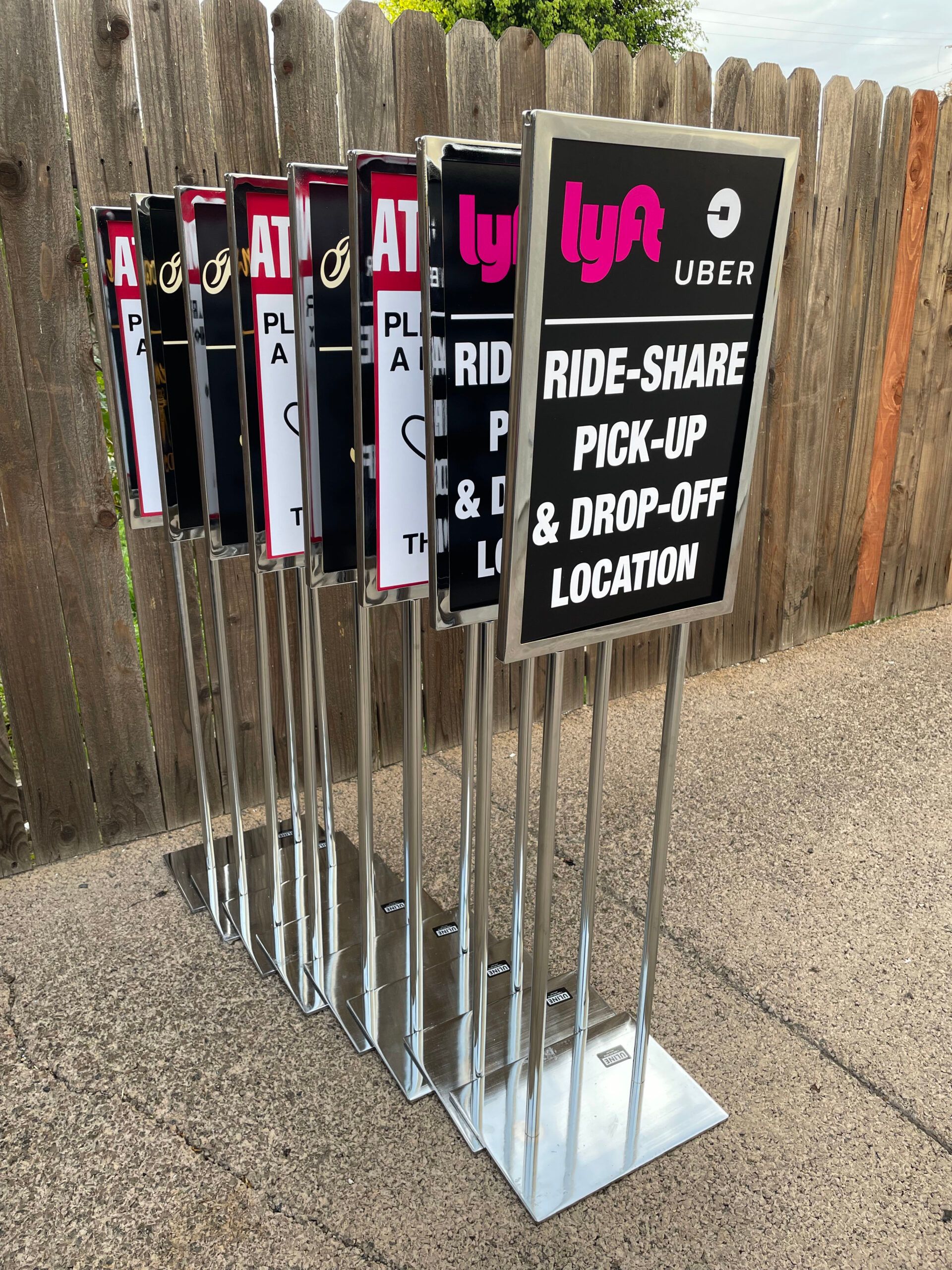 A bunch of signs that say ride share pick up and drop off location